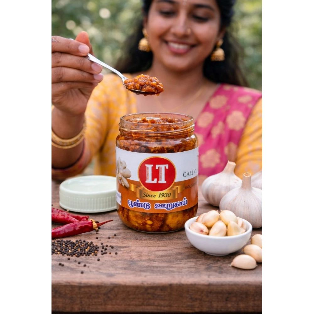 Red garlic pickle jar with a spoonful, plus garlic cloves
