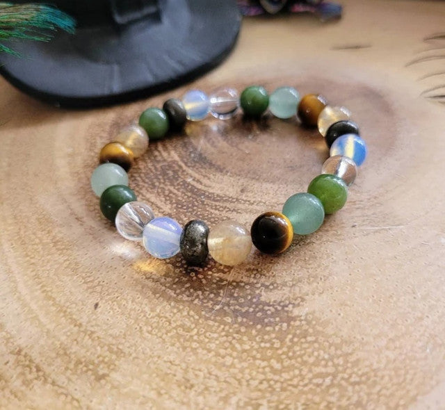 Multicolor crystal bead bracelet with green, gold, black, and clear opal round beads on hand