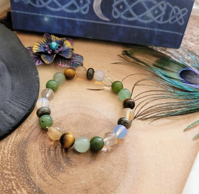Multicolor crystal bead bracelet with green, black, gold, and clear opal beads on a person
