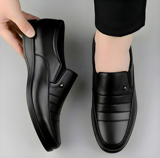 Black slip-on formal shoes with stitched panels and round toe